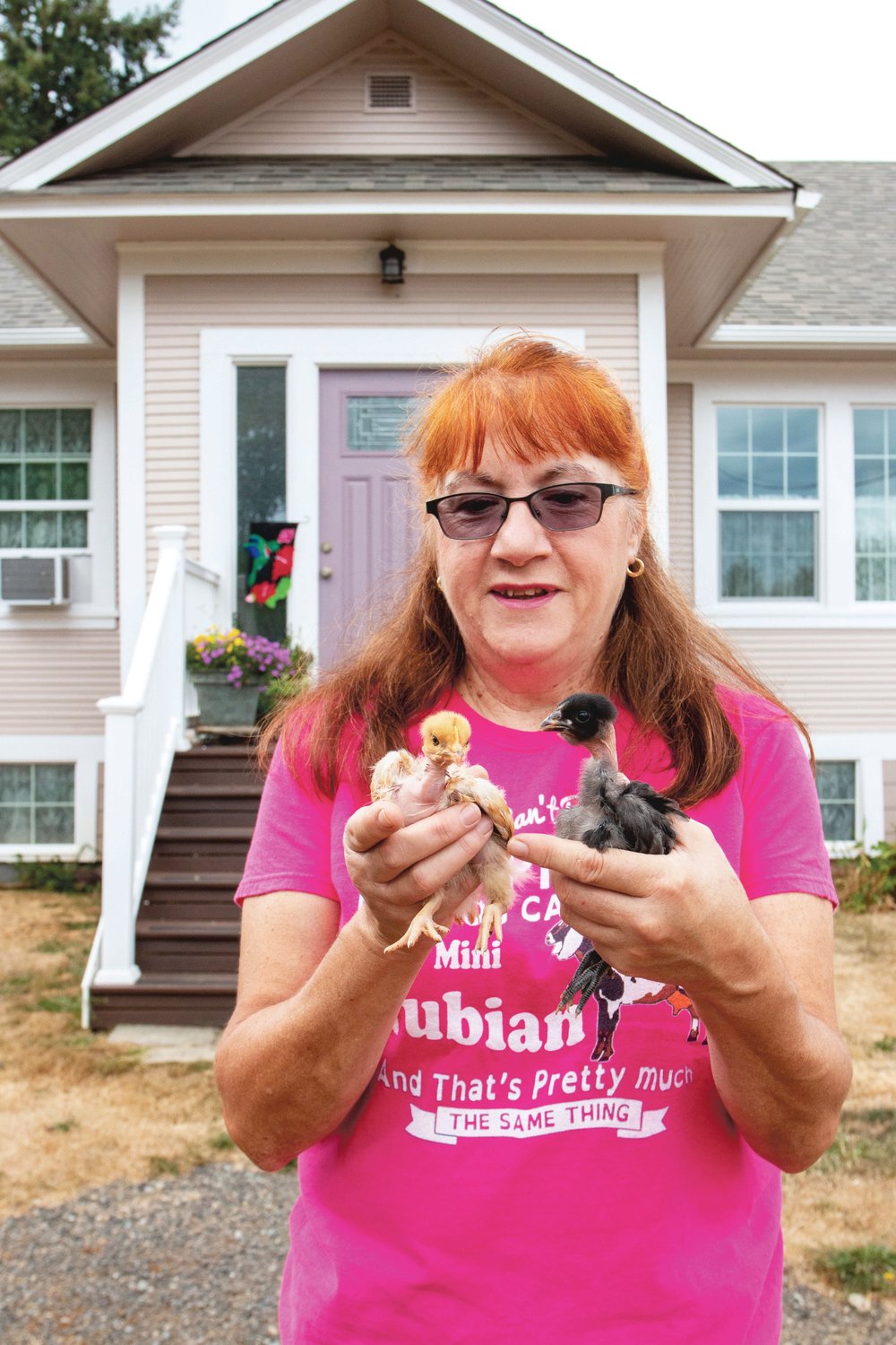 Roxi Willoughby holds a pair of her naked neck chicks in front of her home in Winlock.